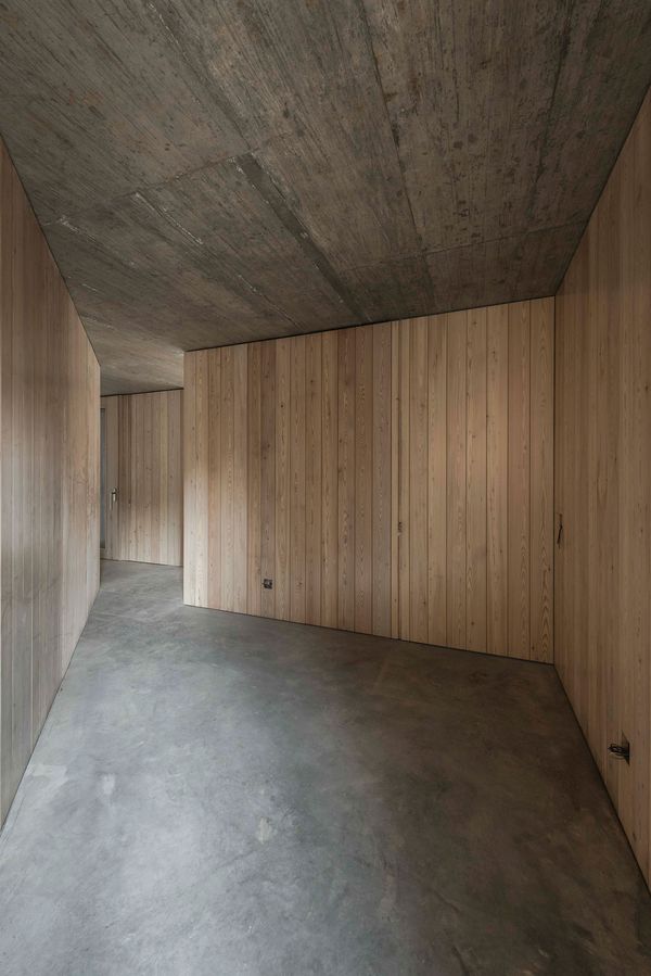 Interior en madera maciza con techo de hormigón visto