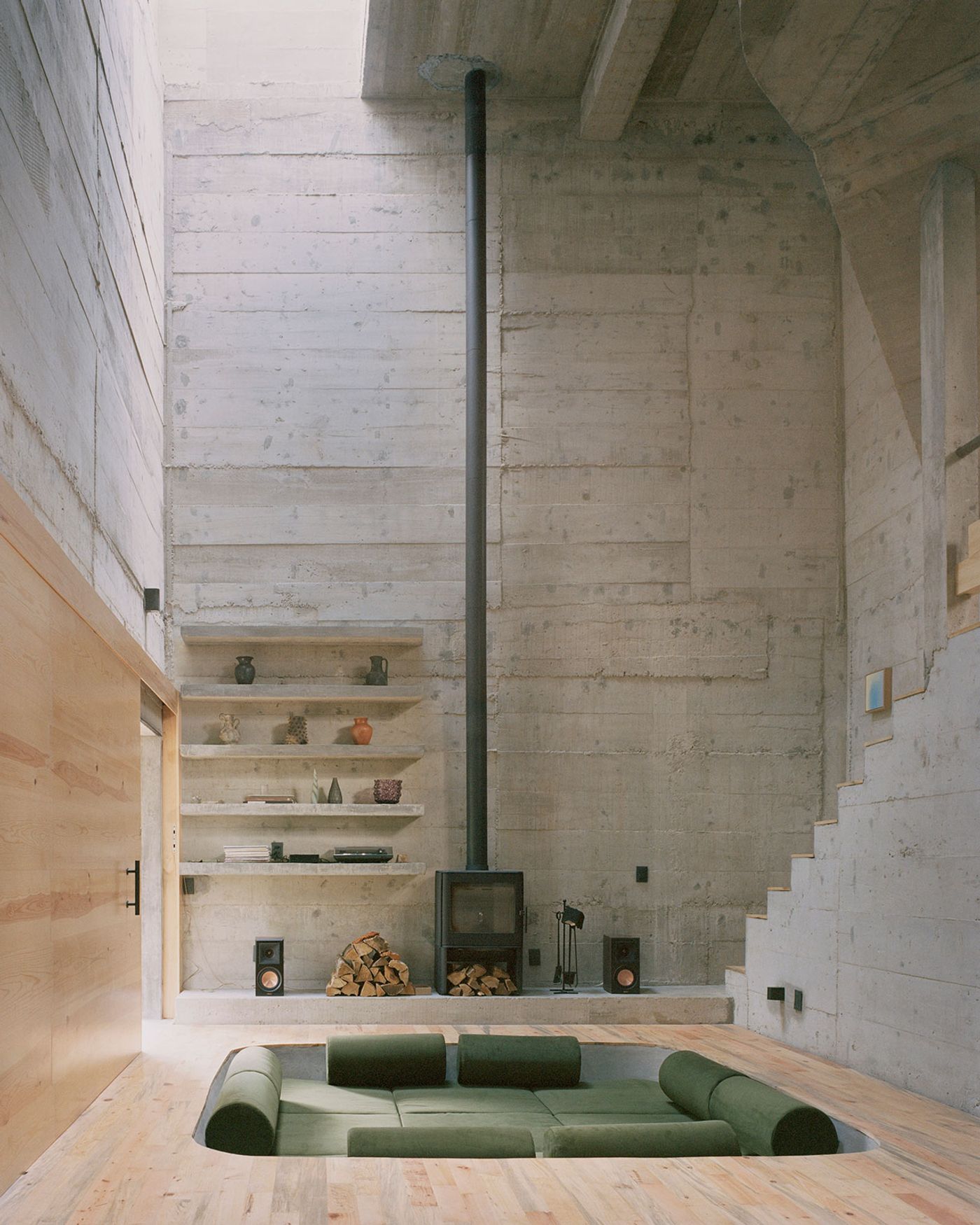 Salón de doble altura en hormigón visto y madera